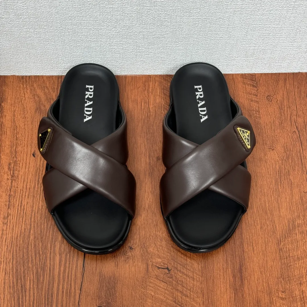Batch 580 Prada/Prada's new men's leather cross slippers. Velcro closure can finely adjust the size. Calf leather light luxury slippers. Thick soft calf leather wraps the upper. Fat but soft rubber lazy style, soft and comfortable, excellent foot feel. Genuine leather bottom layer, cross style, with a Velcro closure buckle, easy to adjust the appropriate size, and a perfect fit for the wearing experience. The enamel gold triangle logo highlights the brand's classic features. Lightweight rubber thin sole, high foot comfort! Complete package! Size: 39-40-41-42-43-44-45 Leather shoe size Item number: 2X7132 Brown